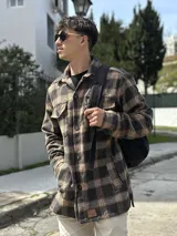 Sobrecamisa a cuadros color gris y beige, con cuello clásico, cierre frontal con botones, dos bolsillos con solapa en el pecho y corte recto.