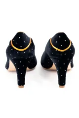 Zapatos de tacón de línea clásica confeccionados en terciopelo negro con aplicaciones de plata. Presentan un diseño estructurado con puntera, laterales y talonera divididos por ribetes en piel tornasolada, con interior en piel y suela de cuero.