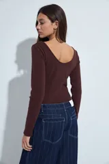 Body de manga larga en color blanco, confeccionado en tejido acanalado con ajuste al cuerpo y escote redondo.