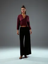 Top corto color bordó, con escote en V, mangas largas abullonadas con puños elásticos y fruncido en la parte delantera.