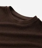 Remera masculina de manga corta, cuello redondo y color marrón oscuro, confeccionada en tejido acanalado de poliéster y algodón.