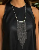 Collar largo de estilo cascada con cadena plateada, compuesto por una pieza central curva y múltiples cadenas finas colgantes con pequeñas esferas metálicas integradas.
