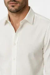 Camisa de poliéster color marrón, de corte holgado, con mangas largas, cuello camisero clásico y cierre frontal de botones.