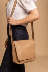 Bandolera de diseño simple con tapa frontal, confeccionada en material símil cuero. Cuenta con correa ajustable, división interna y bolsillos internos para mayor organización.