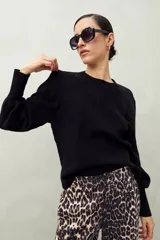 Sweater negro de tejido de punto con mangas abullonadas y puños elastizados.