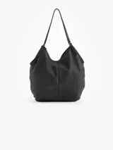 Bolso tipo hobo confeccionado en cuero vacuno con efecto rugoso, de color negro, con manija larga de hombro y ribetes en cuero liso. Incluye un llavero colgante de cuero con la marca grabada.