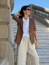 Blazer blanco de lino con solapas y bolsillos frontales.