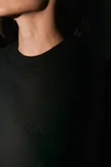 Buzo negro oversize de frisa con cuello redondo, hombros caídos y terminaciones de rib. Presenta logo bordado a tono en el frente y estampa serigrafiada a contratono en la espalda.