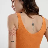 Top tejido color naranja, sin mangas, con escote redondo y detalle de punto calado en el ruedo inferior con borde festoneado.