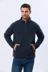 Buzo de abrigo de polar color negro, con cuello alto, medio cierre metálico frontal y bolsillos laterales con cierre. Presenta logo a tono bordado en el pecho.
