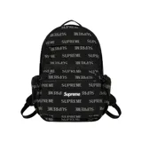 Mochila Supreme de color negro con estampado integral de la marca en tono gris y un bolsillo frontal con el logo clásico en caja roja y blanca.
