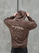 Canguro marrón con capucha ajustable con cordones, bolsillo tipo canguro y puños elásticos. Presenta un logo de un globo terráqueo y una flor bordados en el pecho.