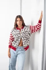 Saco de punto con diseño combinado, presenta un estampado animal print en el cuerpo y mangas con rayas horizontales en rojo y beige. Posee cuello redondo, cierre frontal con botones y terminaciones en tejido acanalado rojo.