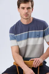 Remera de manga corta y cuello redondo, con diseño de bloques de color y franjas horizontales en tonos azul, celeste y gris, con pequeño logo bordado en el pecho.