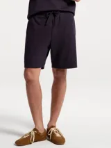 Bermuda de corte recto y diseño minimalista, confeccionada en tejido de punto con cintura elástica y cordón ajustable.