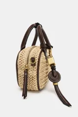 Bolso pequeño tipo bowling de rafia tejida en color natural, con ribetes, asas de mano y detalles en cuero marrón oscuro. Incluye un charm colgante con candado dorado y una correa ajustable extraíble para llevar al hombro o cruzado.