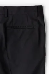 Pantalón de traje de corte ajustado, con cierre y corchete oculto, bolsillos laterales y bolsillos traseros ribeteados. Presenta raya marcada en las piernas y diseño con margen de costura en la pretina.