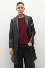 Blazer negro de eco cuero con solapas, cierre de botón frontal y pespuntes blancos en los bordes.