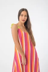 Vestido de fibrana con rayas verticales en colores rosa, naranja y blanco. Tiene breteles finos y lazos en los hombros.
