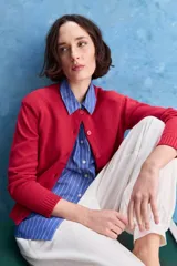 Cardigan rojo de tejido de punto con cuello redondo, manga larga y cierre frontal de botones.