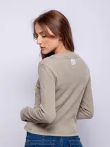 Remera de manga larga confeccionada en tela tipo waffle, con cuello redondo y estampa desgastada en el frente.