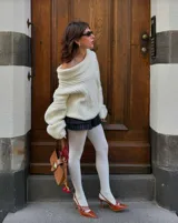 Buzo tejido de punto color crudo con diseño off-shoulder, textura acanalada y calce relajado.