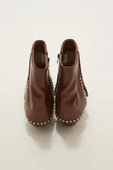 Bota corta de cuero color marrón con acabado degradado en la punta, tacón cuadrado y detalle de tachas metálicas plateadas en la parte superior del pie y el lateral.