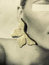 Par de aros dorados con forma de media flor, con detalle de strass negro y gancho de acero quirúrgico.