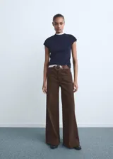 Jeans wide leg tiro alto de color marrón, con cinco bolsillos, trabillas y cierre frontal de botón y cremallera.