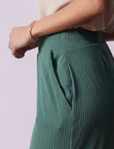 Pantalón capri plisado color beige, marca Dictionary, con pretina ancha elastizada y bolsillos delanteros.