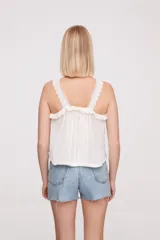 Musculosa blanca con breteles finos y detalles de puntilla.