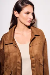 Sobrecamisa marrón de gamuza sintética, con cuello camisero, cierre frontal con botones, mangas largas con puños abotonados y bolsillos de parche en el pecho.