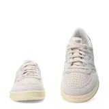 Championes urbanos New Balance modelo Court, color beige con detalles en crema y suela de goma con efecto envejecido. Presentan el logo N característico en los laterales y perforaciones en la puntera para mayor ventilación.