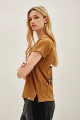 Remera de algodón color marrón mostaza con estampado en la espalda de un ojo místico rodeado de fases lunares, estrellas y motivos florales en color negro.