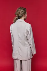 Blazer beige de corte recto, con solapa clásica, bolsillos frontales con solapa y cierre de un botón.