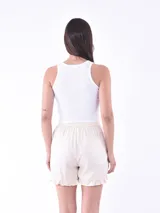 Short de tela fluida color coral, con cintura elástica, cordón de ajuste y detalle de volados en el ruedo.
