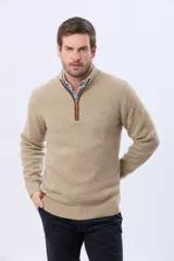 Buzo tejido de punto grueso en color azul marino, con cuello alto y cierre frontal parcial. Presenta detalles en gamuza en la zona del cierre y una textura en relieve en toda la prenda.