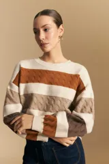 Sweater de tejido de punto con diseño de rayas horizontales en tonos azul y blanco. Presenta cuello redondo, puños y ruedo acanalados, con un sutil patrón de relieve en el tejido.