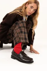 Zapato náutico de cuero color chocolate con horma cuadrada. Presenta detalles de pasamanería en cuero descarne que recorren el frente y los laterales, cordones frontales y suela plana con pequeño taco.