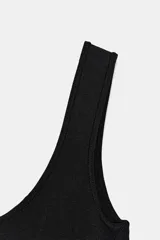 Body negro de escote cuadrado y tirantes anchos, con cierre de broches en la parte inferior.