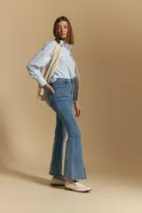 Jean oxford de tiro alto confeccionado en denim con spandex, de color gris oscuro lavado. Presenta un corte ajustado en la parte superior que se ensancha hacia el ruedo, el cual incluye aberturas frontales.