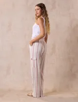 Pantalón cargo de lino a rayas verticales grises y blancas, marca Marissa Olivia. Pretina ancha elastizada con lazo de ajuste, bolsillos inclinados delanteros y bolsillos laterales con botón.
