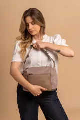 Bandolera de diseño práctico con combinación de texturas en tonos tierra, confeccionada en tela y símil cuero. Cuenta con un compartimento principal con cierre, un bolsillo frontal con cierre y correa ajustable para llevar al hombro o cruzada.