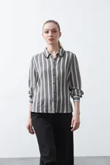 Camisa de manga larga color marrón con estampado de lunares blancos, confeccionada en tejido liviano con cuello clásico y botones frontales.