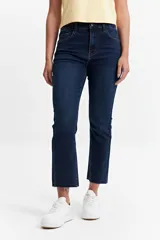 Jean straight de tiro medio, color azul denim, con corte recto y ruedo desflecado.