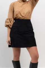Minifalda negra de velvetine con spandex y bolsillos frontales.