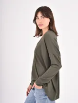 Remera de manga larga color verde oliva, con cuello en V y diseño holgado con caída fluida.