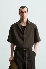 Camisa de corte relajado confeccionada en tejido con mezcla de modal, con cuello solapa, manga corta y cierre frontal de botones.