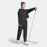 Pantalón deportivo Adidas negro, de corte holgado, confeccionado en felpa con tecnología AEROREADY. Presenta cintura elástica con cordón ajustable y puños elásticos en los tobillos.