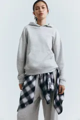 Buzo con capucha de doble capa, hombros caídos y bolsillo canguro frontal. Tejido de punto con interior cepillado suave y puños y bajo acanalados.